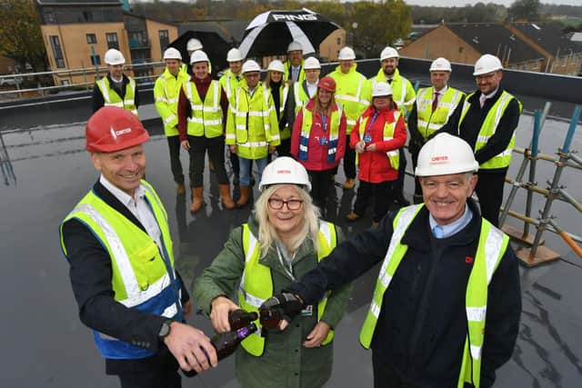 Adam Brewster Heltwate School Headteacher, Cllr Lynne Ayres and Russell Benson, the Carter site manager at the topping out ceremony for the new school extension in Bretton.