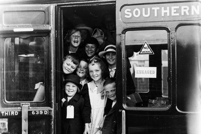 Evacuees smile for the camera as they board a train. The News PP306