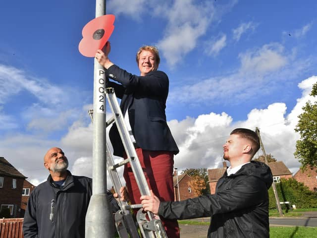 Peterborough MP Paul Bristow putting up giant poppies in Central Avenue, Dogsthorpe with Cllr Ishfaq Hussain and party worker Benjamin O'Hara