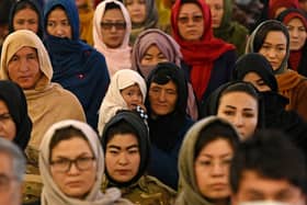 A Hazara woman (C) holds her child as she with others attend an event on International Women's Day in Bamiyan Province on March 8, 2021. (Photo by WAKIL KOHSAR / AFP) (Photo by WAKIL KOHSAR/AFP via Getty Images)