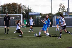 Evie Driscoll-King (blue) in action for Posh Women at Cambridge City.  Photo: Ruby Red Photography