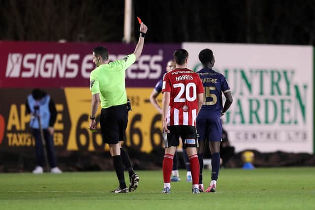 Michael Olakigbe is shown the red card by referee Tom Reeves. Photo: Joe Dent.