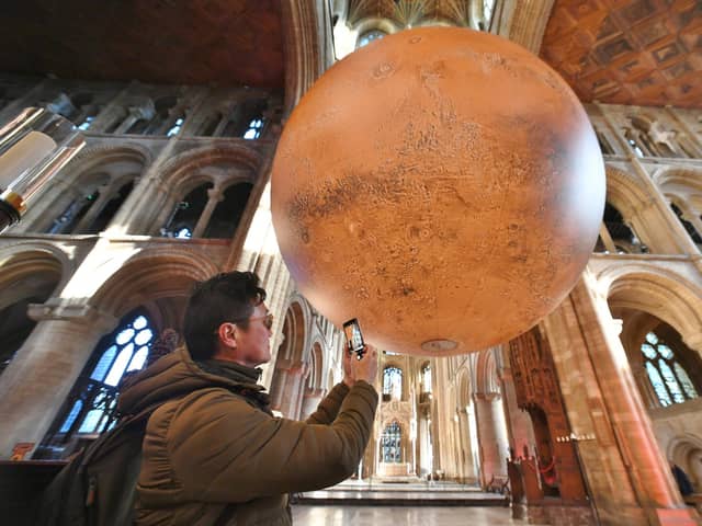 Visitor Kevin Chung looking at the planet at the opening of the Mars: War and Peace exhibition
