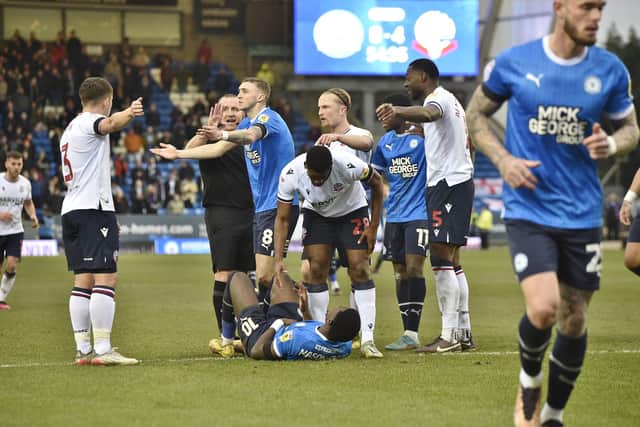 Posh forward Ephron Mason-Clark is down after a challenge by Bolton skipper Ricardo Santos. Photo: David Lowndes.
