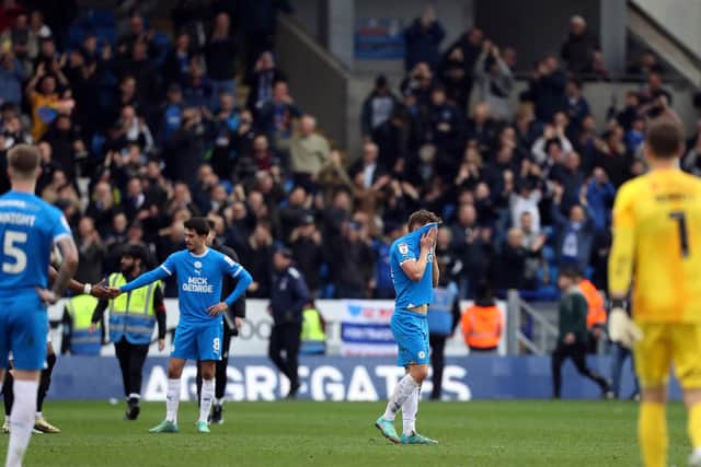 Peterborough United players look dejected at full-time in front of the Portsmouth fans. Photo: Joe Dent.