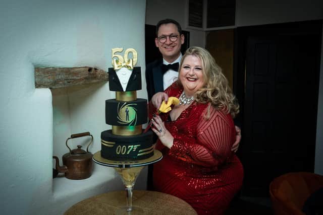 Karen Pauls celebrated her 50th birthday with a James Bond themed party - pictured with husband Andrew Pauls cutting her cake by Lisa Brown's All About Cakes