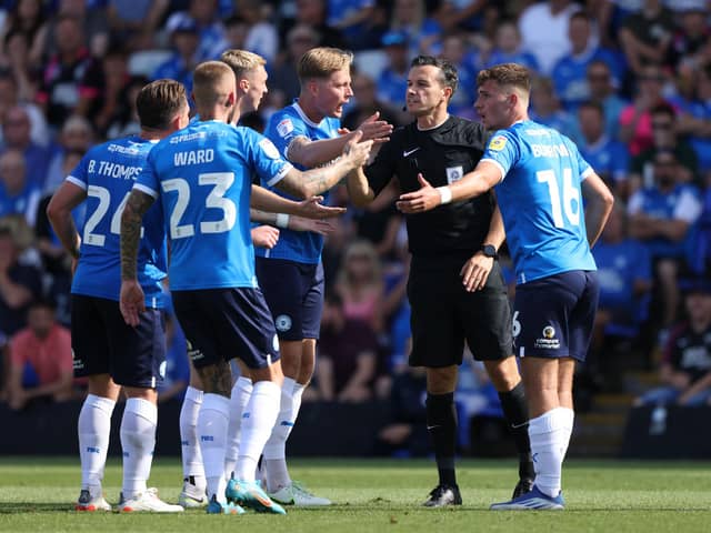 Posh players protest against referee Dean Whitestone's decision not to award them a penalty against Morecambe. Photo: Paul Marriott.