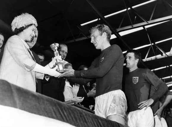 Queen Elizabeth II presents the World Cup to England captain Bobby Moore at Wembley in 1966. Photo: PAFP via Getty Images.