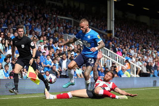 Joe Ward of Peterborough United skips past Teddy Bishop of Lincoln City. Photo: Joe Dent/theposh.com.