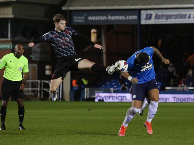 Jonson Clarke-Harris of Peterborough United in action with Luca Connell of Barnsley. Photo: Joe Dent/theposh.com