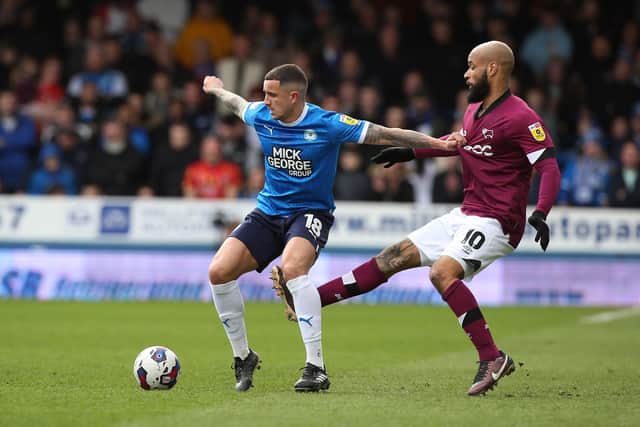 Oliver Norburn of Peterborough United in action with David McGoldrick of Derby County. Photo: Joe Dent/theposh.com.