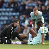 Ricky-Jade Jones of Peterborough United receives treatment after getting injured. Photo: Joe Dent.