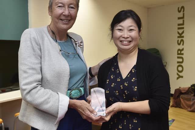 Lord Lieutenant for Cambridgeshire Julie Spence presents the Queens Award to Voluntary Service to  Faustina Yang of Hampton Tiddlers.
