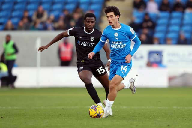 Joel Randall of Peterborough United gets away from Beryly Lubala of Burton Albion. Photo: Joe Dent.
