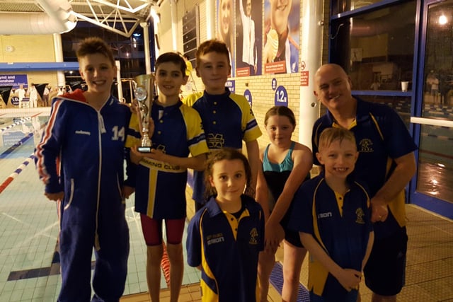 One youngster from Mansfield Swimming Club proudly shows off a trophy with his team-mates.