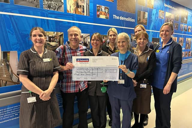 Chris Porsz presents oncologist Dr Karen McAdam and her team with a cheque for £1,500.