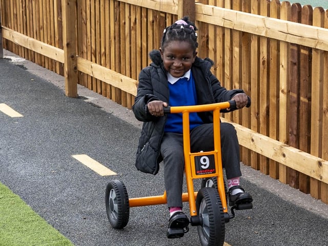 A pupil enjoys the new play area's riding track