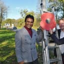 MP for Peterborough Paul Bristow, Zillur Hussain and Cllr Charles Fenner putting up giant poppies on lamp posts in Bretton.