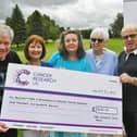 David Walker and Don Collins from The Wrinkle Rock Band hand over a cheque for £1,600 to Ann Hanson, Jo Keogh MBE and Jan Gray from the Burghley Park and Peterborough Ladies for Cancer Research group at Burghley Park Golf Club.