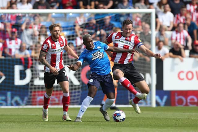 Jeando Fuchs of Peterborough United battles with Tom Hopper of Lincoln City. Photo: Joe Dent/theposh.com