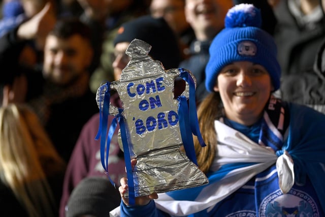 A Peterborough United fan holds their homemade tinfoil FA Cup prior to the Manchester City match.