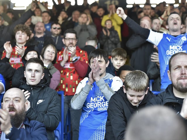 Peterborough United fans are pictured watching the crucial win over Derby County.