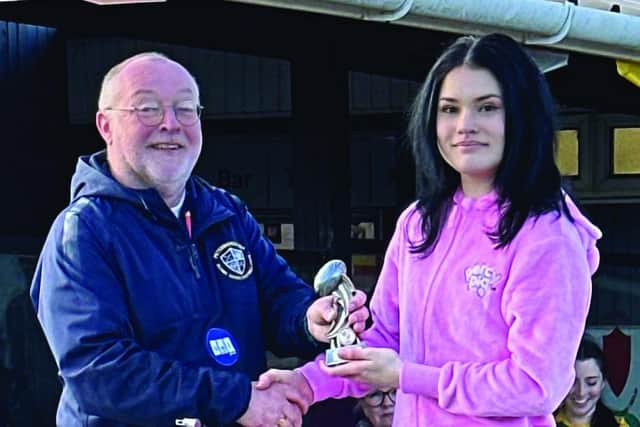 Borough Under 16 girls captain Gabby Clarke receives the winner's trophy.