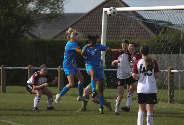 Ruby Gockel (blue, left) heads goalwards for Peterborough Sports in the Northants U18 Cup Final against Northampton Town. Photo: Tim Symonds