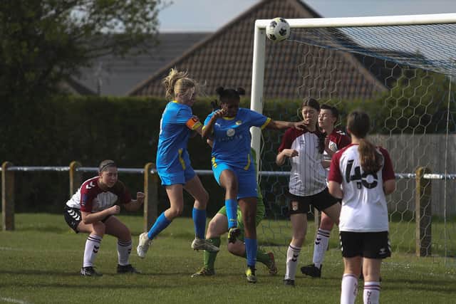 Ruby Gockel (blue, left) heads goalwards for Peterborough Sports in the Northants U18 Cup Final against Northampton Town. Photo: Tim Symonds
