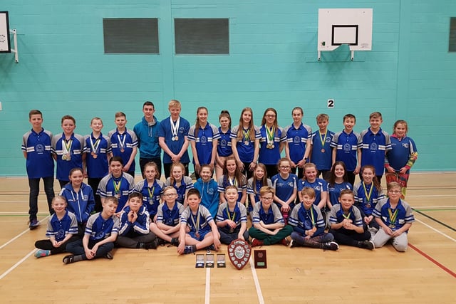 Members of Sutton Swimming Club pose with medals and trophies.