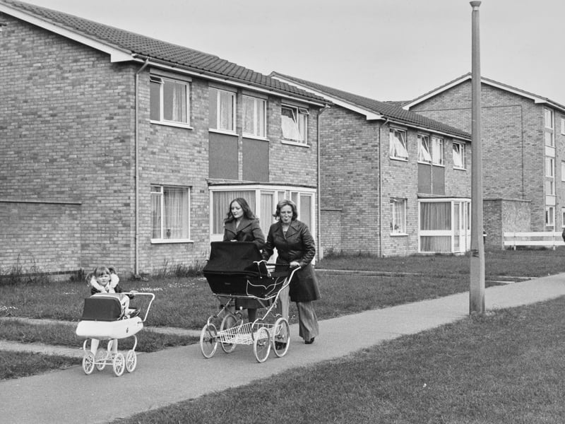 Women pushing a pram past houses on the Ravensthorpe housing estate in April 1976