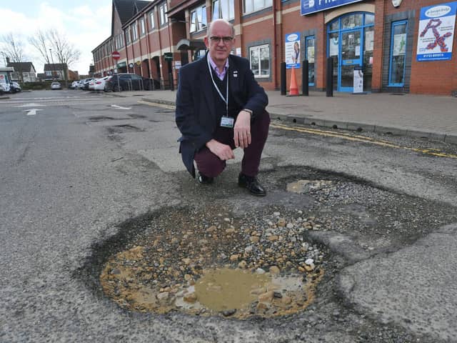  Cllr Andy Coles with potholes at shops at Sugar Way, Woodston