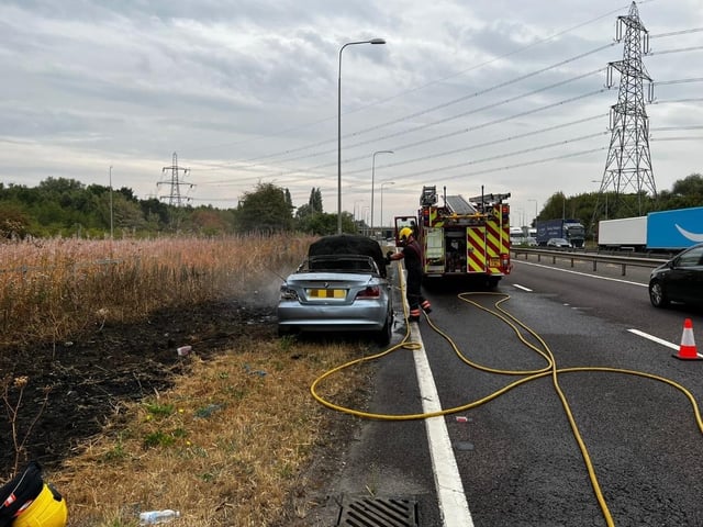 Officers worked alongside fire crews to put out a vehicle fire, which had spread to the dry grass verge.