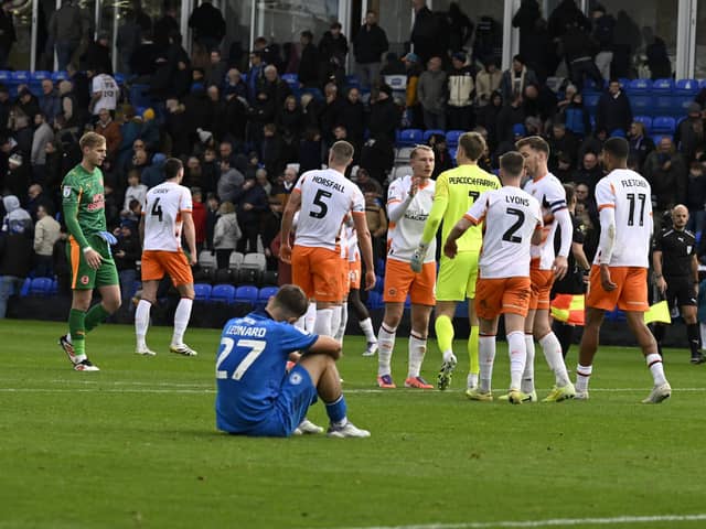 Blackpool players celebrate their win at Posh in front of a dejected Harry Leonard. Photo David Lowndes.