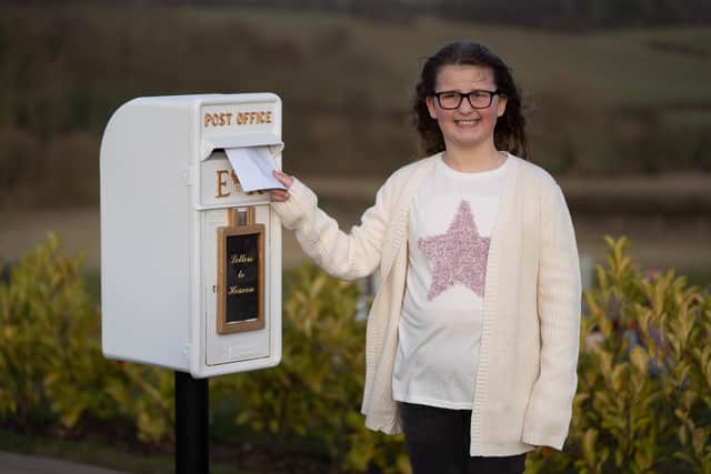 Matilda Handy, 9, with the letter box to heaven, in Gedling Crematorium, which allows grieving members of the public to write a letter to their loved ones who have passed away.   Photo: Tom Maddick SWNS