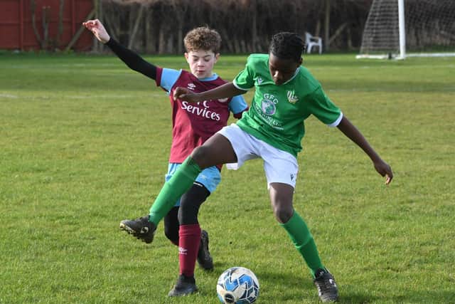 Players from FC Peterborough (green) and Deeping Rangers battle for possession.  Photo: David Lowndes.