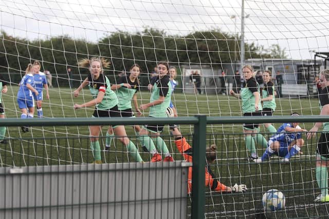 Yas Green (blue, on floor) scores for Yaxley Phonix against Harpenden. Photo: Tim Symonds