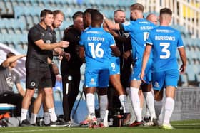 Peterborough United players celebrate the opening goal against Lincoln with manager Darren Ferguson. Photo: Joe Dent/theposh.com.