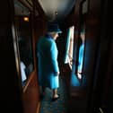 Britain's former Queen Elizabeth II looks out of a window as she travels on a train pulled by the steam locomotive 'Union of South Africa' between engagements in Scotland on September 9, 2015 (PhotoAFP via Getty Images)