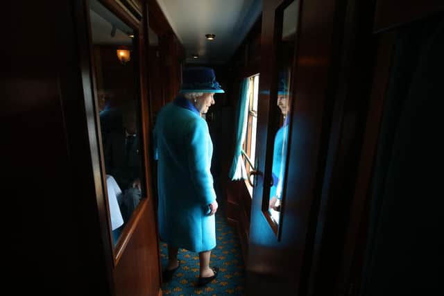 Britain's former Queen Elizabeth II looks out of a window as she travels on a train pulled by the steam locomotive 'Union of South Africa' between engagements in Scotland on September 9, 2015 (PhotoAFP via Getty Images)