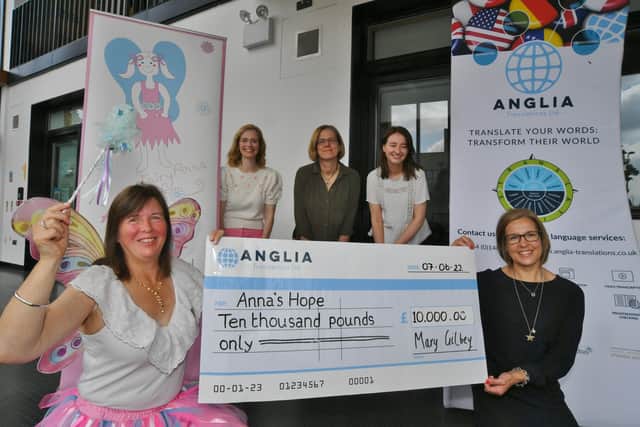 Carole Hughes, founder of the charity Anna's Hope, receives a cheque from Mary Gilbey from Anglia Translations