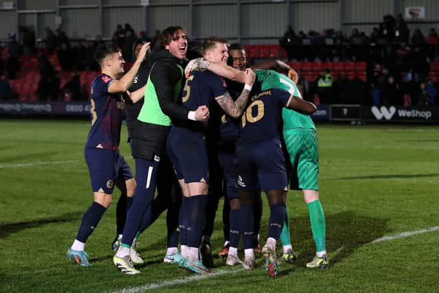 Peterborough United players celebrate winning the penalty shoot-out. Photo: Joe Dent.