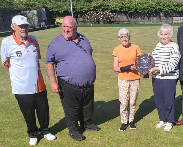 Sherin Noble and Norma Squires are pictured with the Malcolm Squires and Dick Noble Shield alongside (from the left) Adams captain Ray Keating, Hunts manager Bob Morton and Northants president Martyn Dolby.