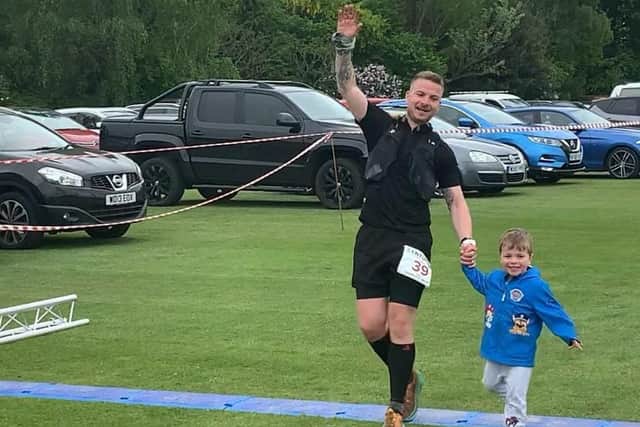 Del Dunworth crossing the finish line with his son, Arlo, 3.