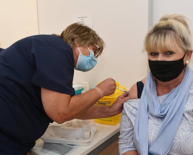 A new covid and flu vaccination campaign has been rolled out early in Peterborough amid fears of a 'twindemic' - topping up jabs given two years ago. Picture shows Monica Allen getting her booster jab at the then NHS vaccination centre in the Queensgate shopping centre in 2021.