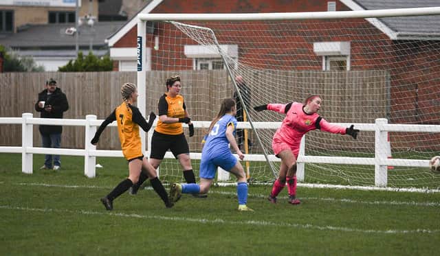 Phoebe Eyett (blue) scores for Peterborough Sports against March. Photo: Tim Symonds.