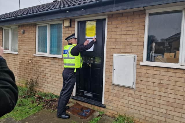 Chief Constable Nick Dean pins the closure order onto the property in Birchwood, Orton Goldhay.