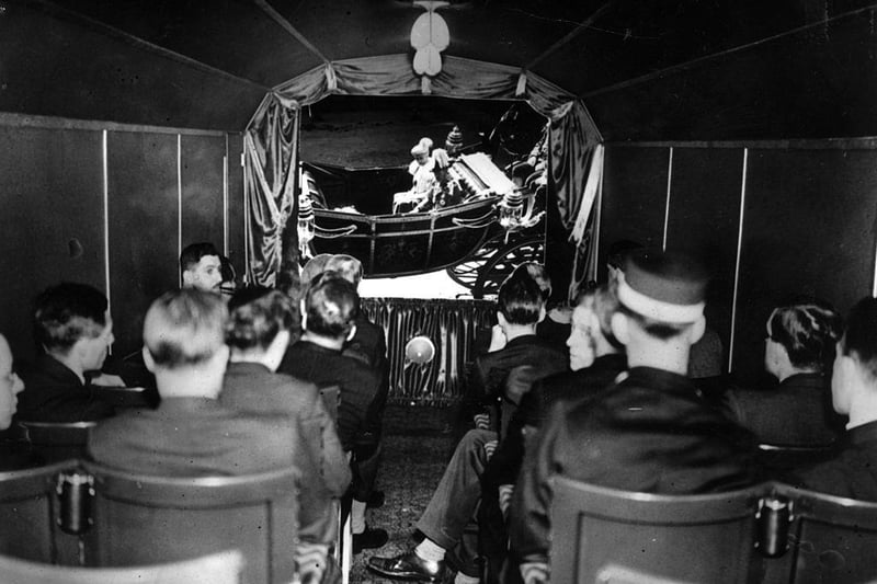 Passengers watch a scene during the showing of the jubilee film on a railway journey from King's Cross, London to Peterborough in 1935. Perhaps an early forerunner to watching a streamed film on a tablet or mobile phone.