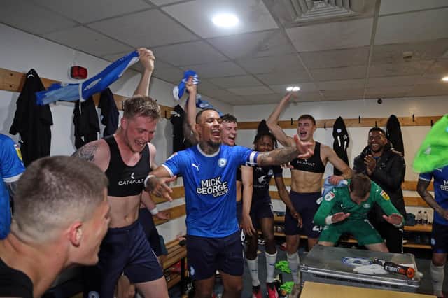Posh celebrate reaching the play-offs in the dressing room after victory over Barnsley. Photo: Joe Dent.
