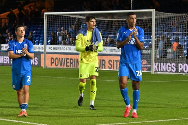 Carl Johnston, Vicente Reyes and David Ogabue applaud the Peterborough United fans at full-time.